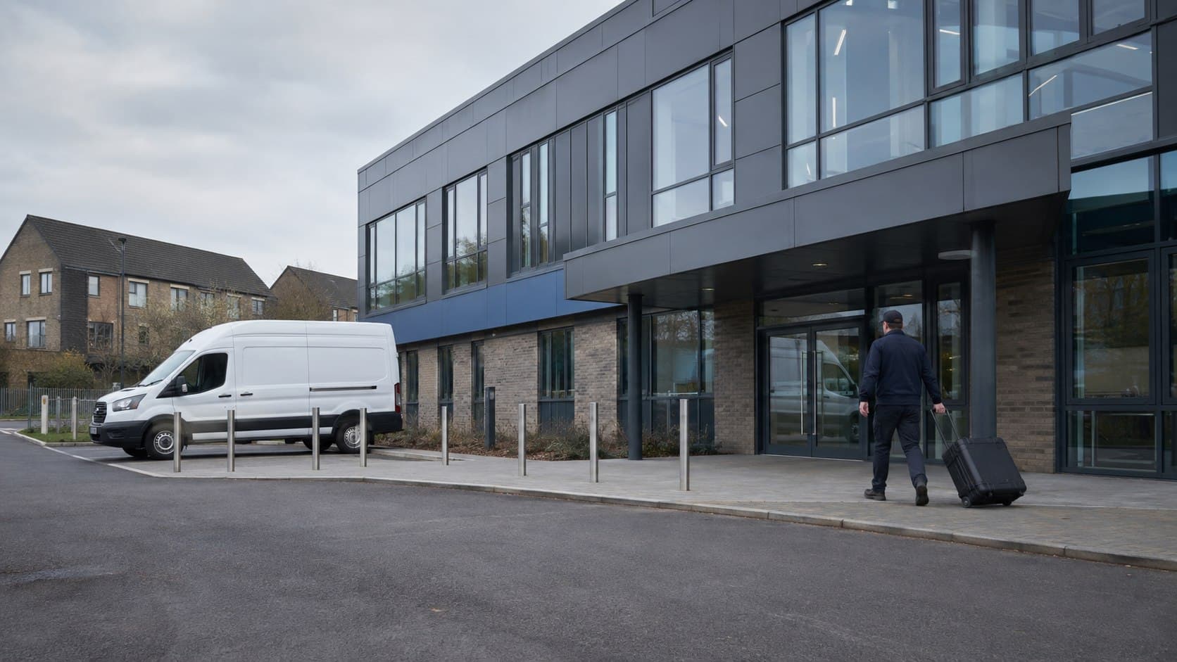 Unbranded courier collecting a prepared consignment in Ardleigh Green, shown in an eastern Hornchurch district with education, retail and residential premises.